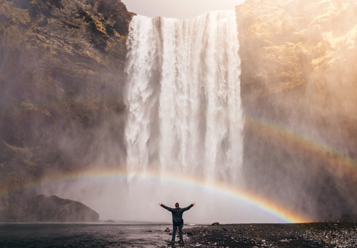 man under waterfall following his curiosity