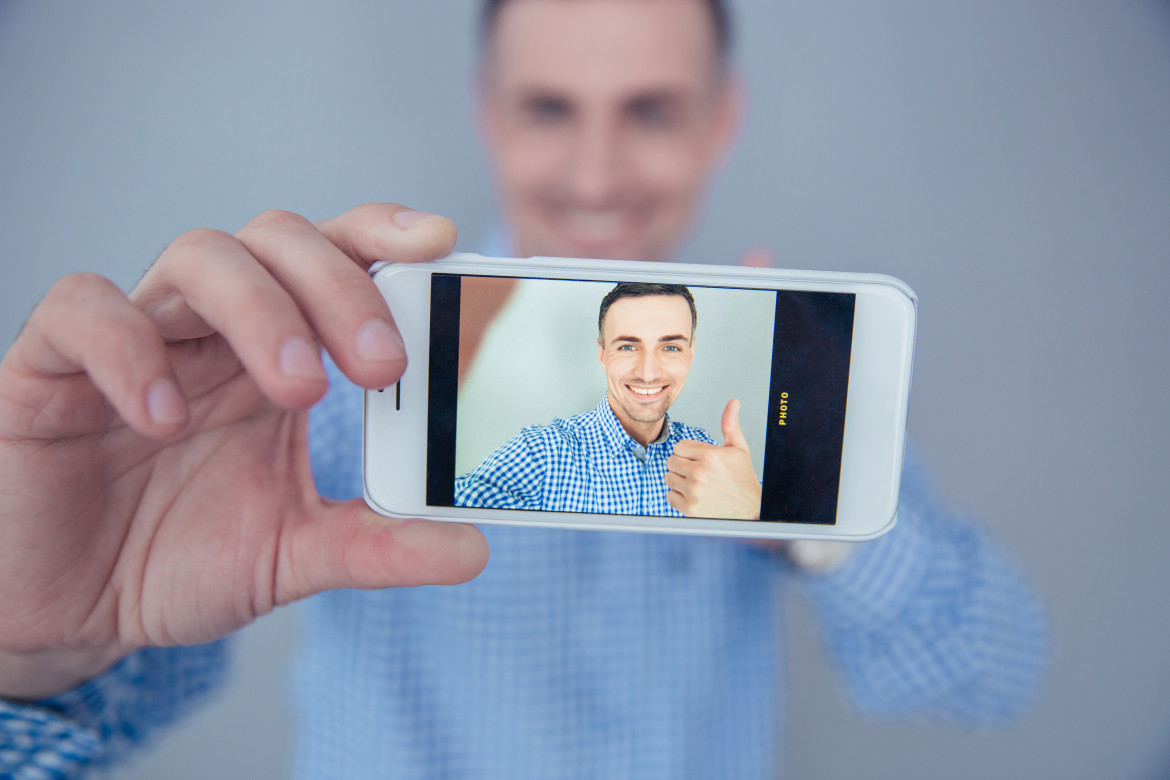 Smiling man making selfie photo